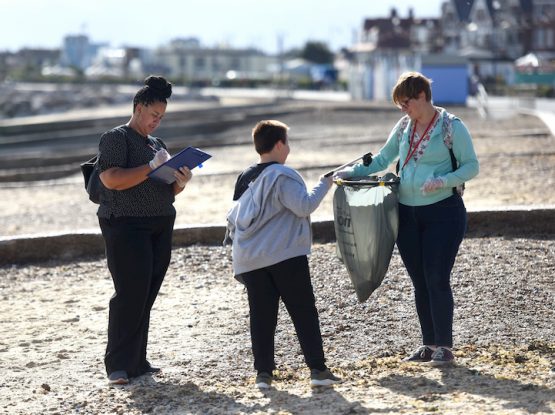 A photo of two women and a boy collecting litter from Felixstowe Beach