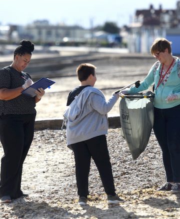 A photo of two women and a boy collecting litter from Felixstowe Beach