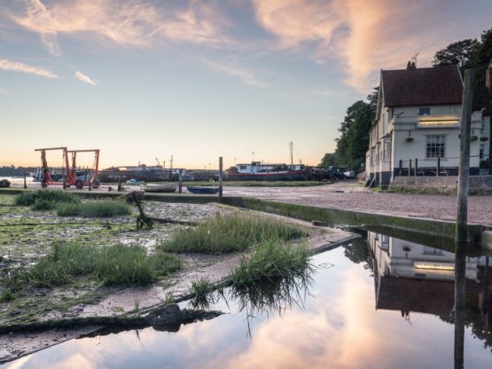 Buildings and boat machinery and Pin Mill with blue skies overhead